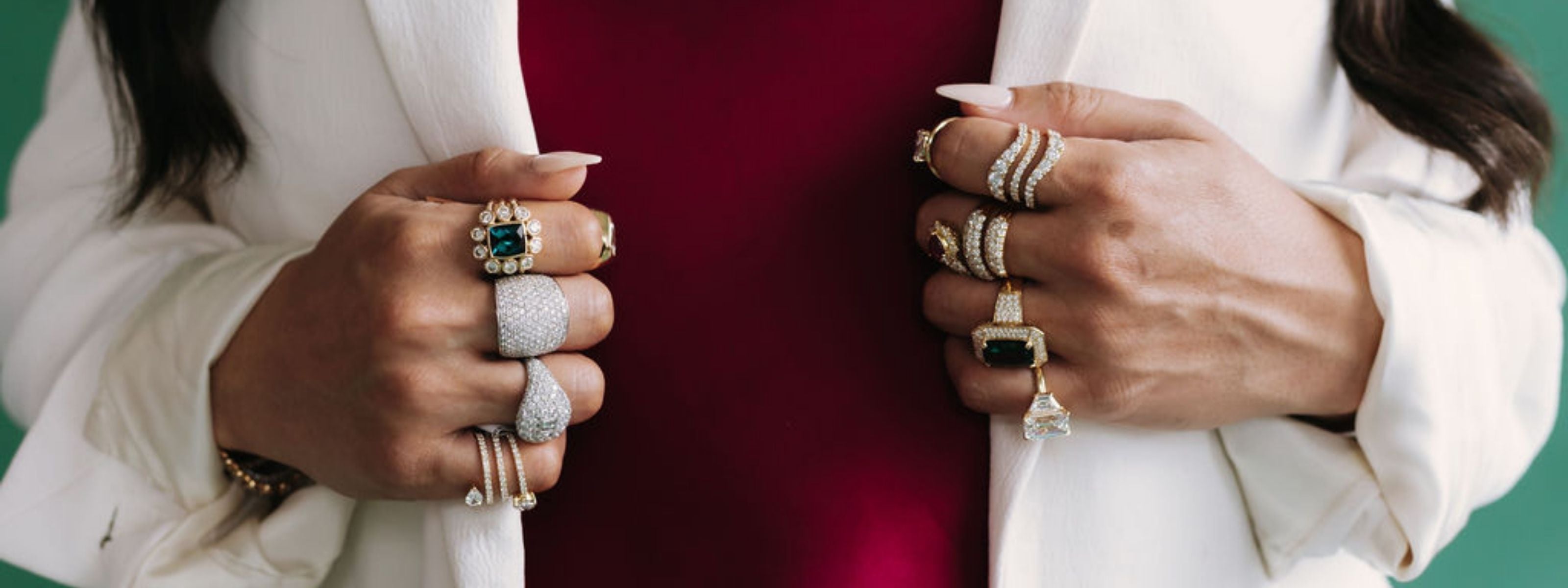 Woman in white blazer wearing stacked diamond and gemstone rings with tennis necklace, Seema Fine Jewelry editorial