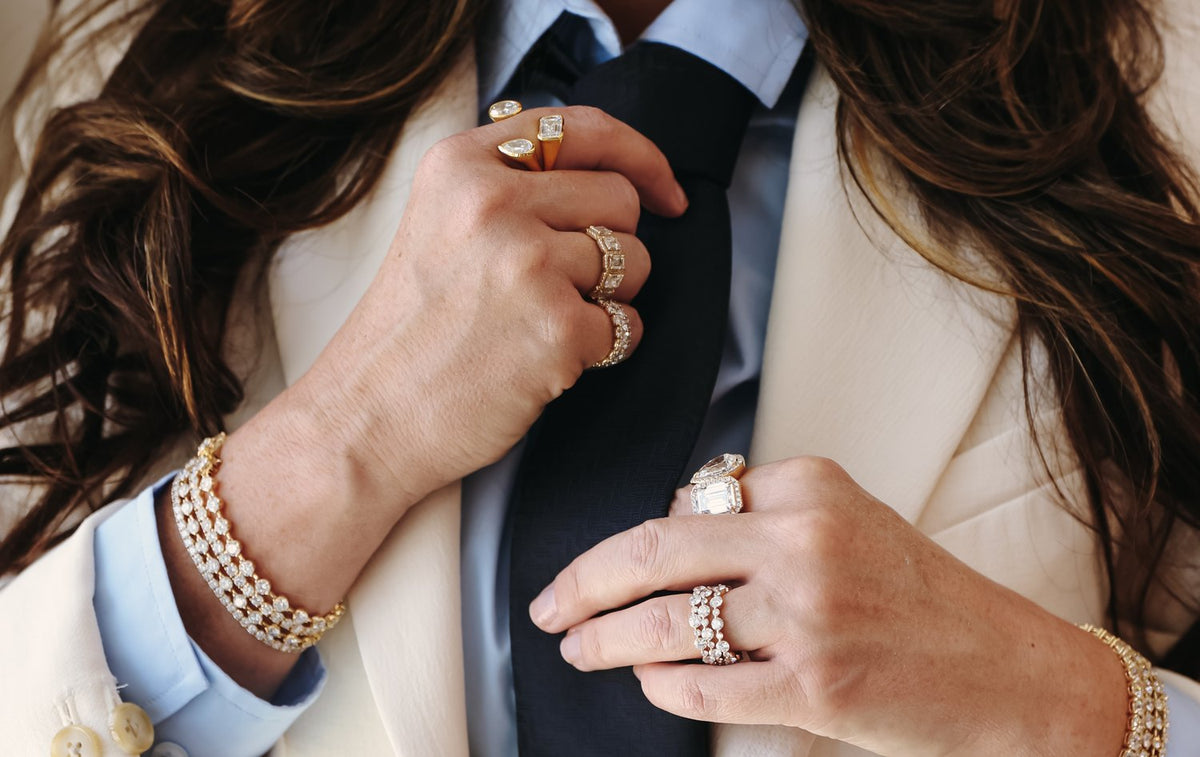 Hands fixing a tie, wearing the Open Mixed-Shape ring and the Three-Row Bubble eternity band